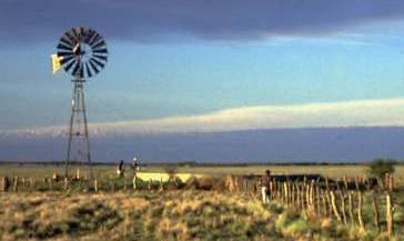 Landscape shot of the Pampean plain showing a windmill used to pump groundwater from a well