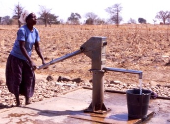 Woman pumping water from a well in Ghana