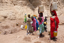 Women and children collecting shallow groundwater (less than 10 m below ground surface) from a hand-dug hole in the soil